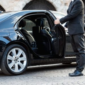 Corporate airport transfers driver opens car door